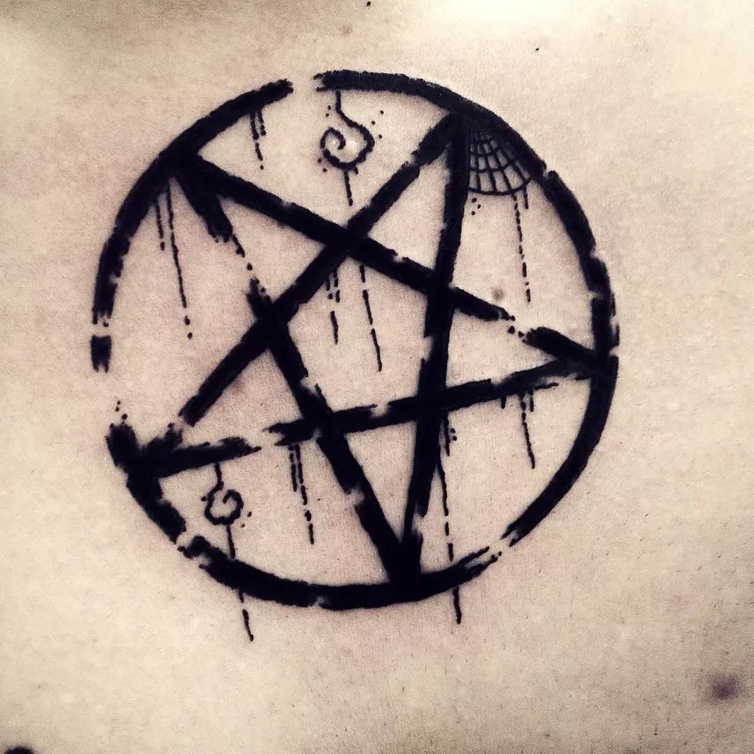 Pentagram tattoo with a distressed, dripping black ink style on human skin.
