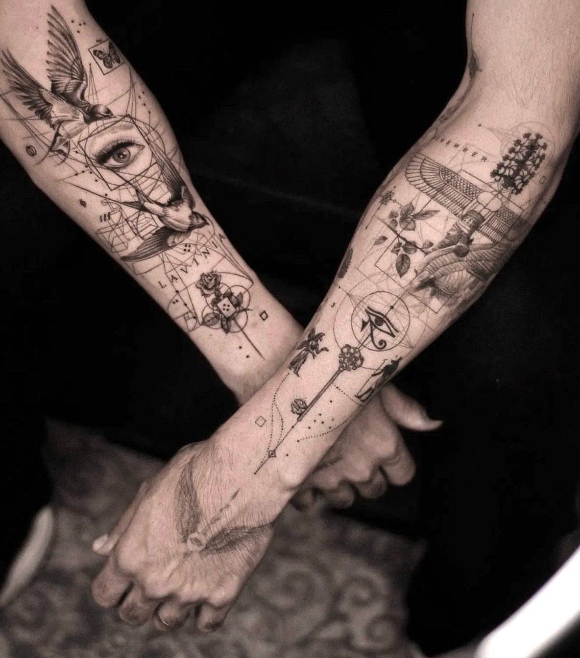 Geometric tattoos on two forearms featuring an eye, birds, and intricate line work.