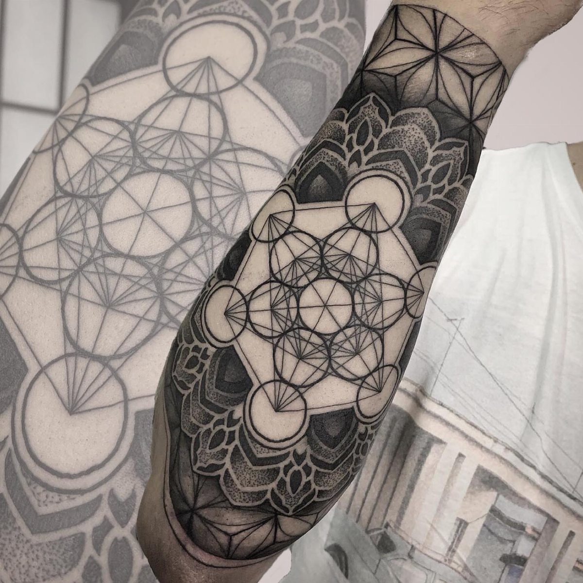 Metatron's Cube tattoo with intricate geometric lines and circles on a forearm.