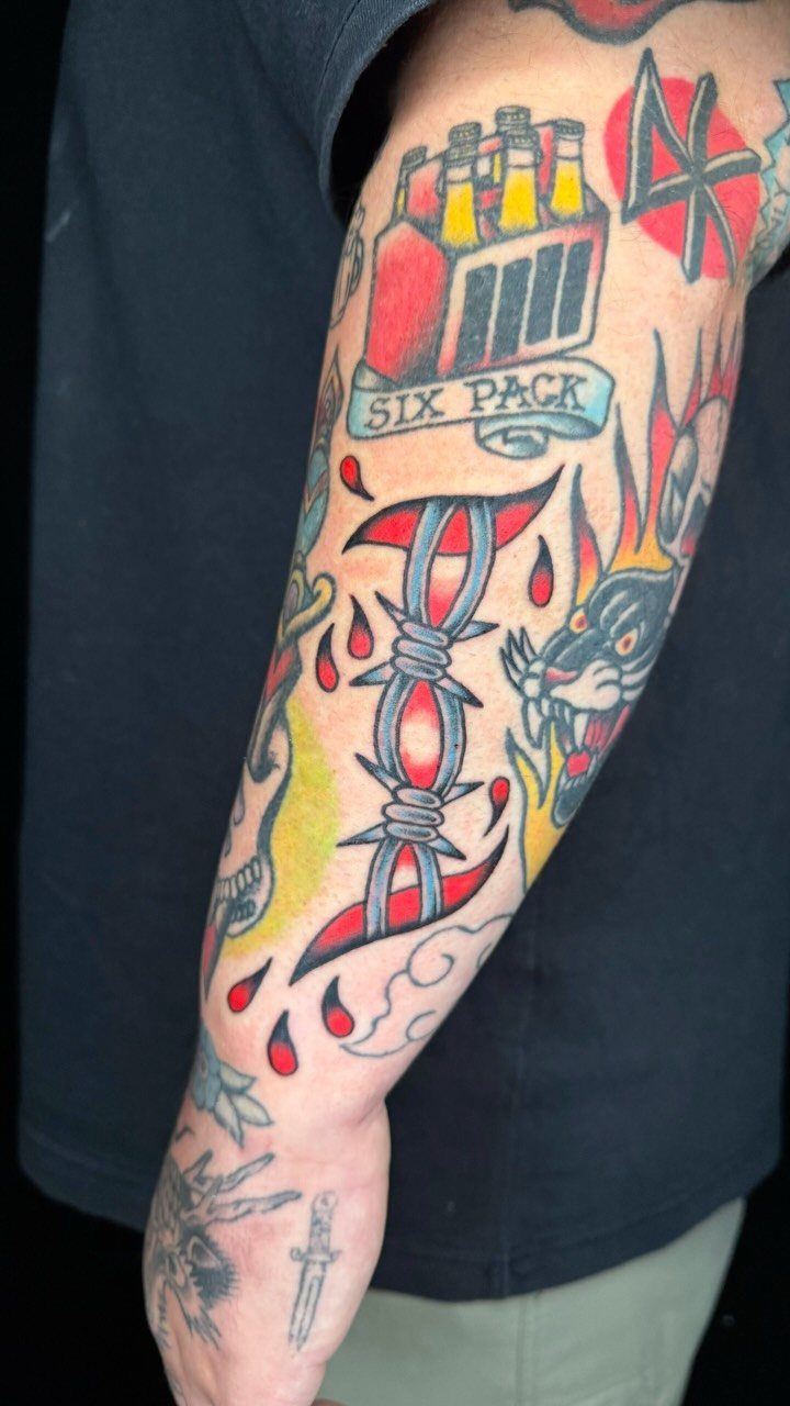 Traditional barbed wire tattoo on an arm alongside a six-pack and panther.