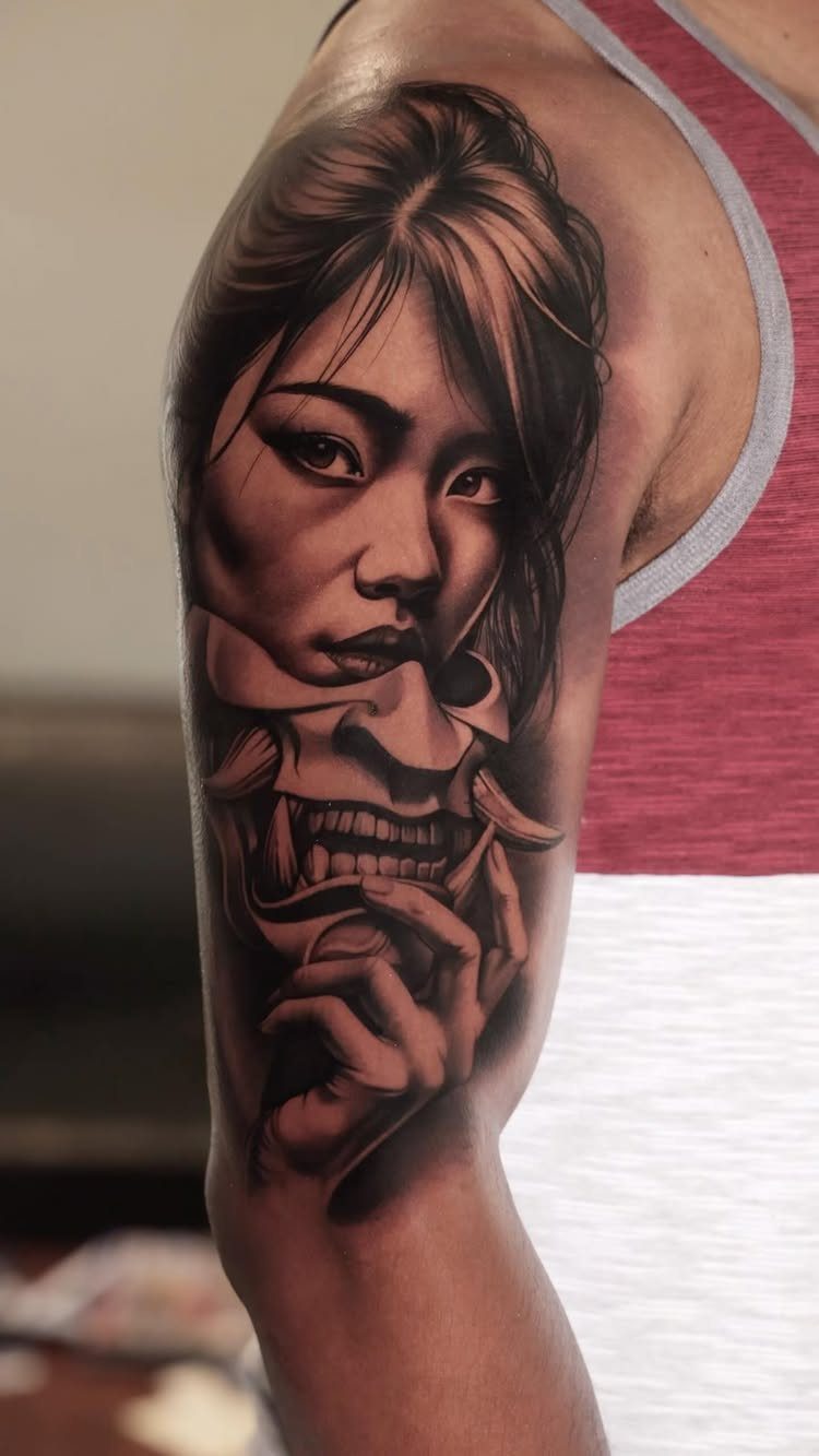 Black and grey realism tattoo of a woman and hannya mask on brown skin.