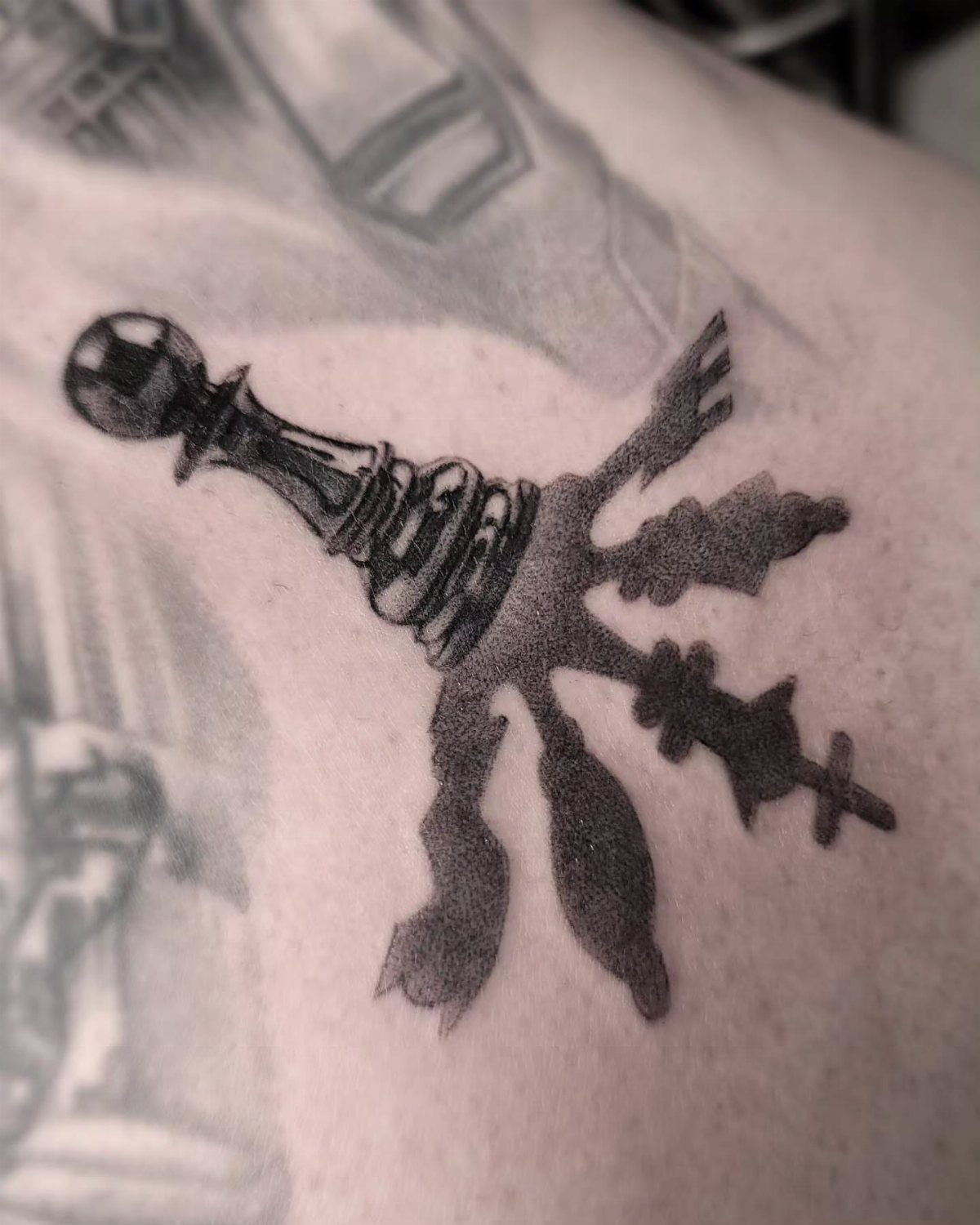 Chess piece tattoo with a dark shadow cast across the skin