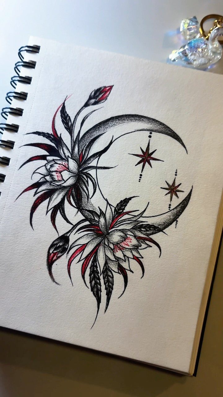 Crescent moon drawing with stars and floral blooms in a spiral notebook