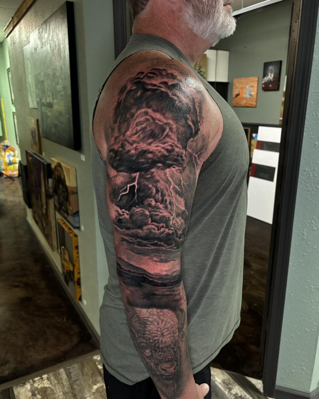 Dark storm cloud tattoo with lightning on a man's upper arm.