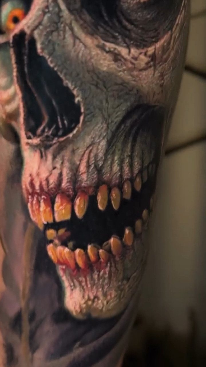 Decaying skull tattoo with yellowed teeth and dark shading on human skin