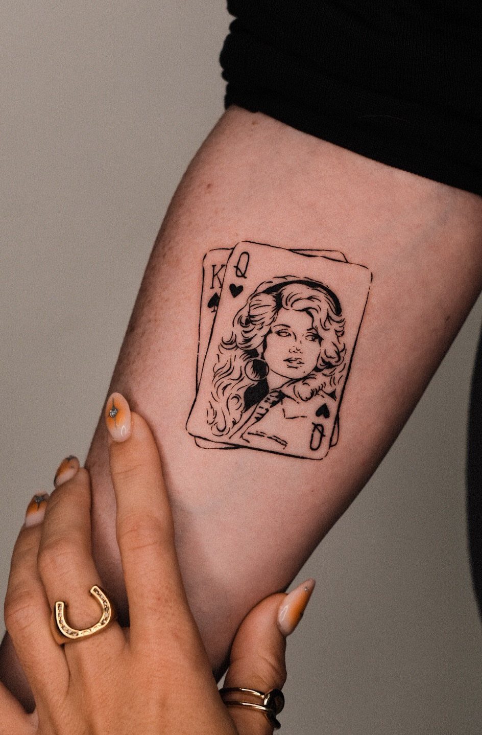 Dolly Parton tattoo as a Queen of Hearts playing card on an arm