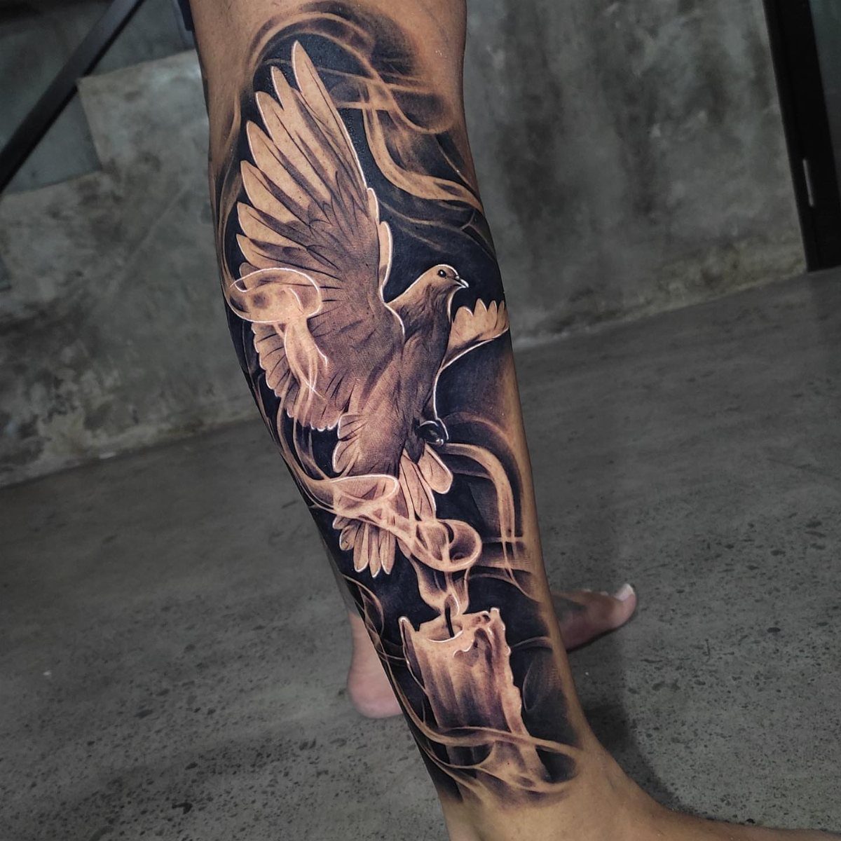 Dove tattoo design on a lower leg featuring a bird and melting candle.