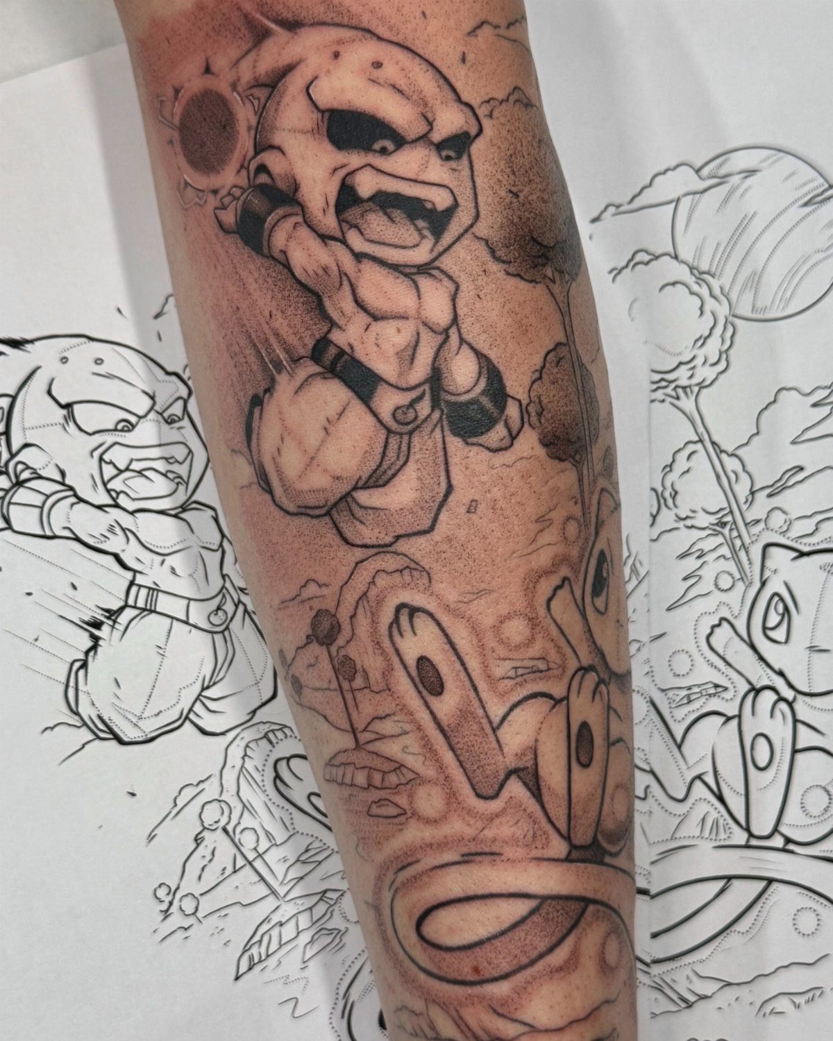 Chibi style Dragon Ball character tattoo on a person's arm with sketches nearby.