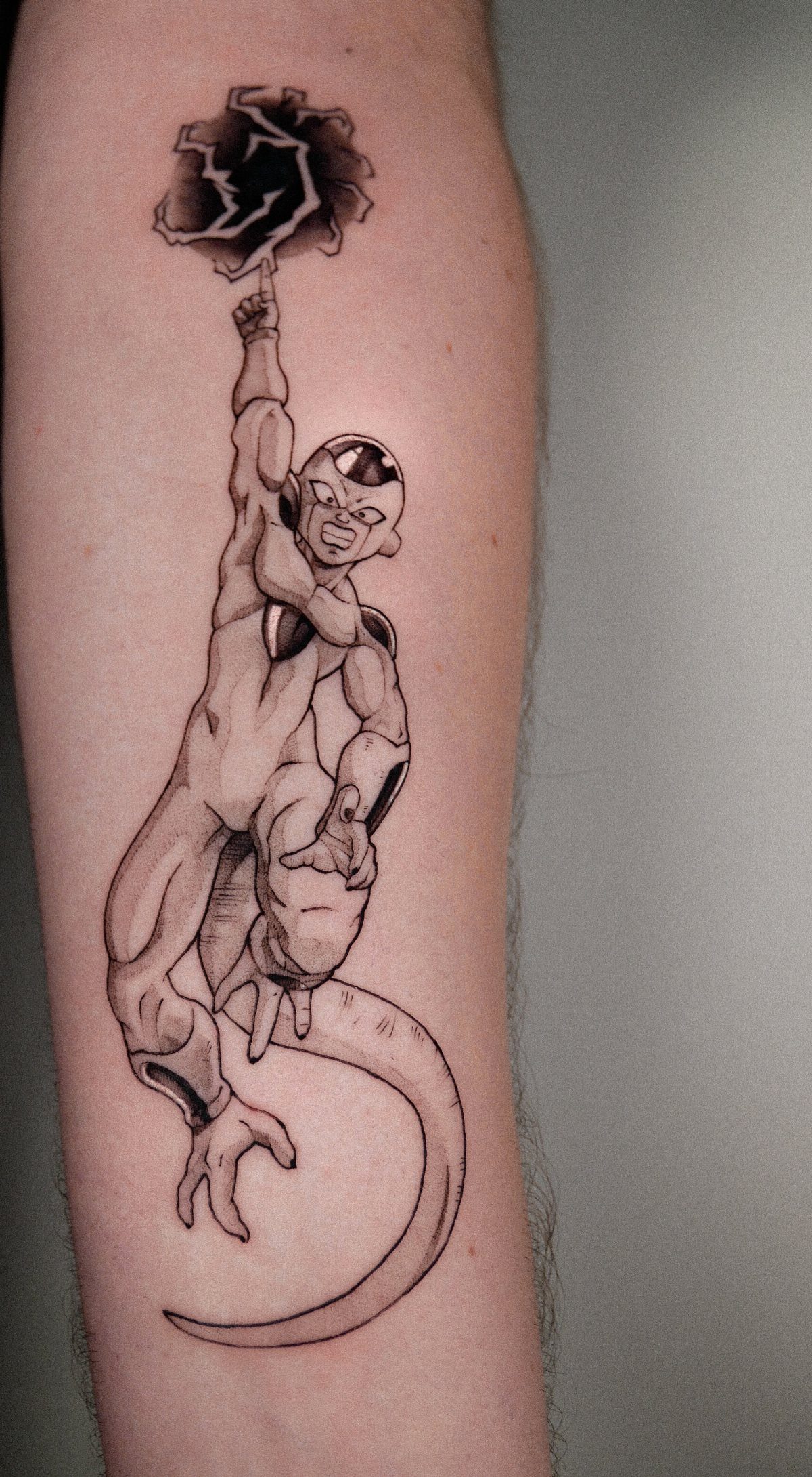 Frieza tattoo on an arm showing the character holding a dark energy sphere.