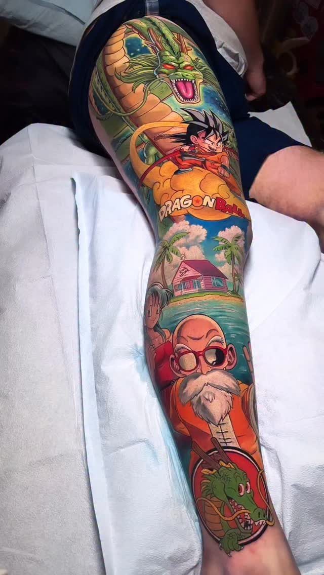 Colorful leg sleeve tattoo featuring Kame House, Master Roshi, Goku, and Shenron dragon.