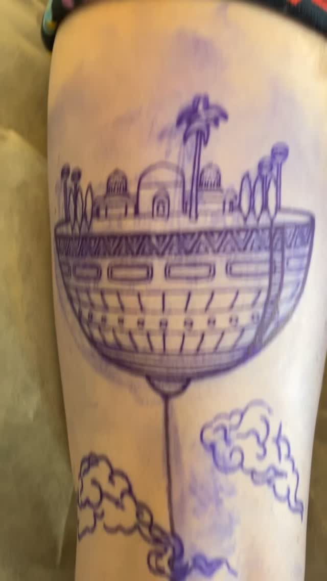Floating city tattoo stencil with domes and palm trees on human skin.