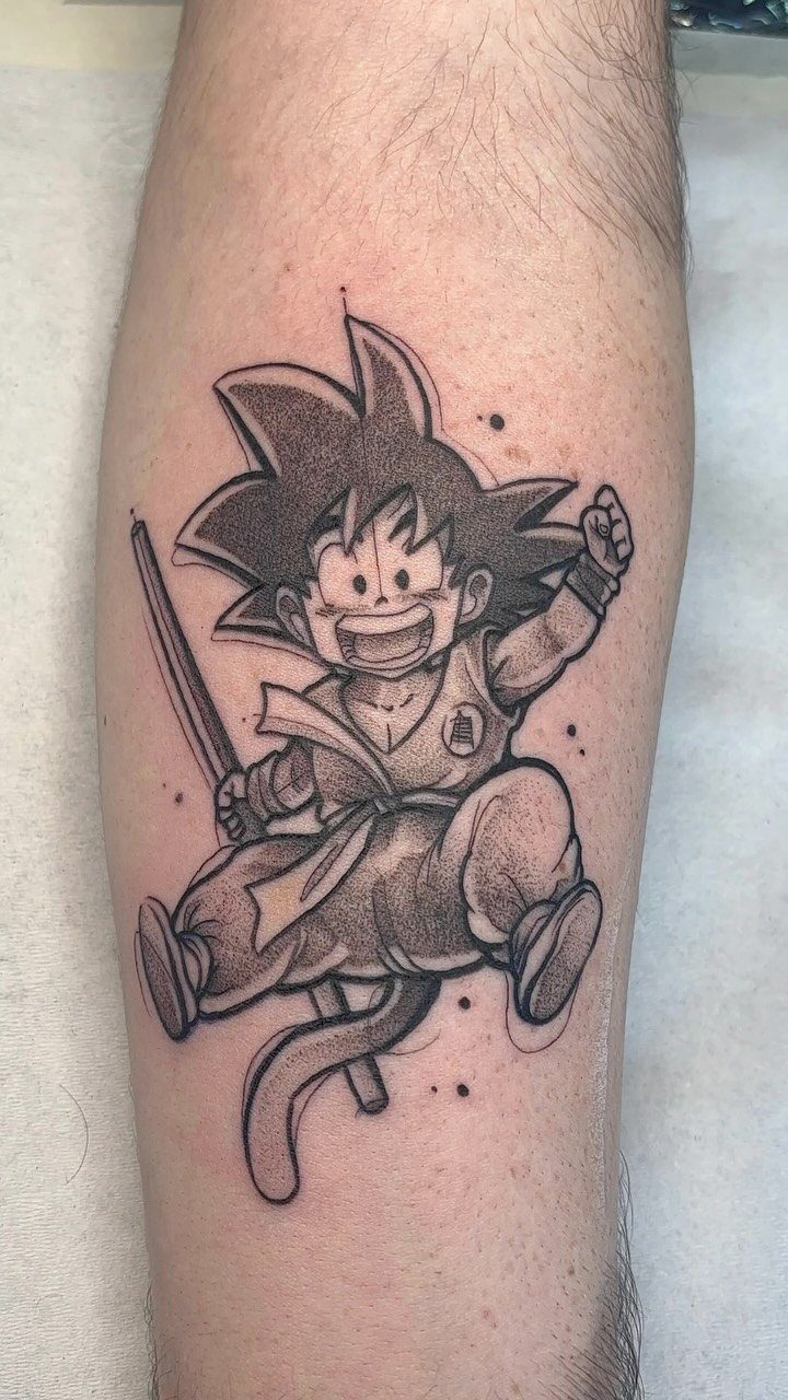 Goku tattoo on a forearm featuring the character with his power pole.
