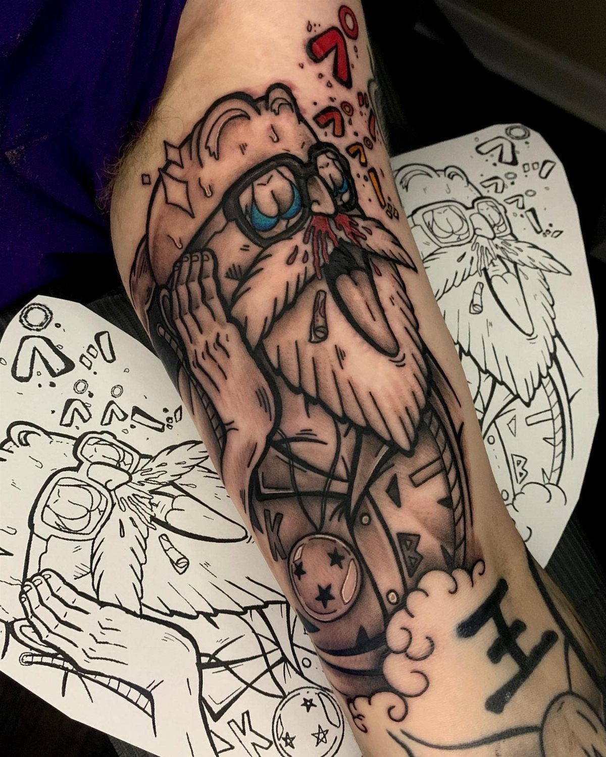 Master Roshi tattoo on an arm with accompanying design stencils on paper.