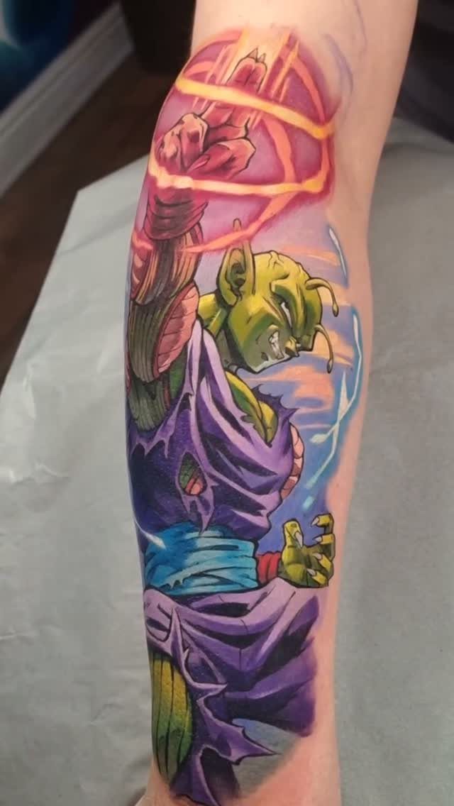 Piccolo tattoo on an arm showing the character charging a glowing energy blast.