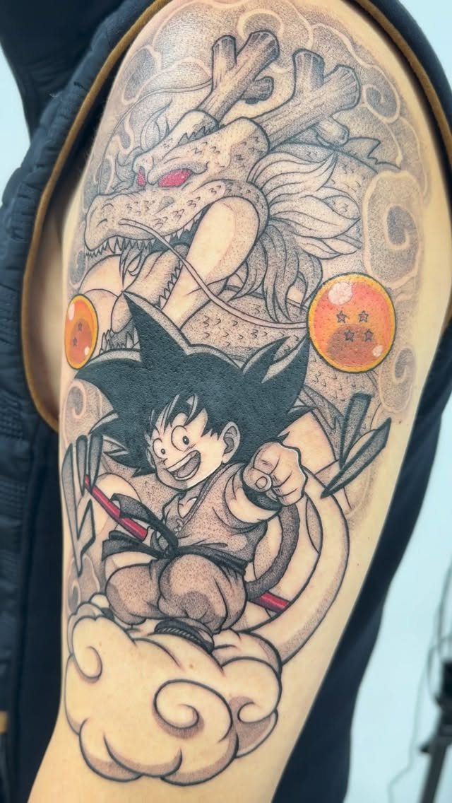 Goku riding a flying nimbus cloud with Shenron and dragon balls tattoo