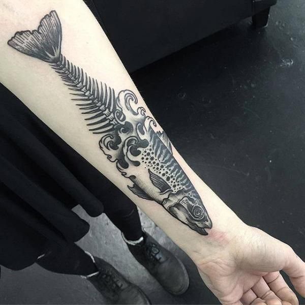 Fish morphing into a skeleton tattoo with waves on a person's forearm