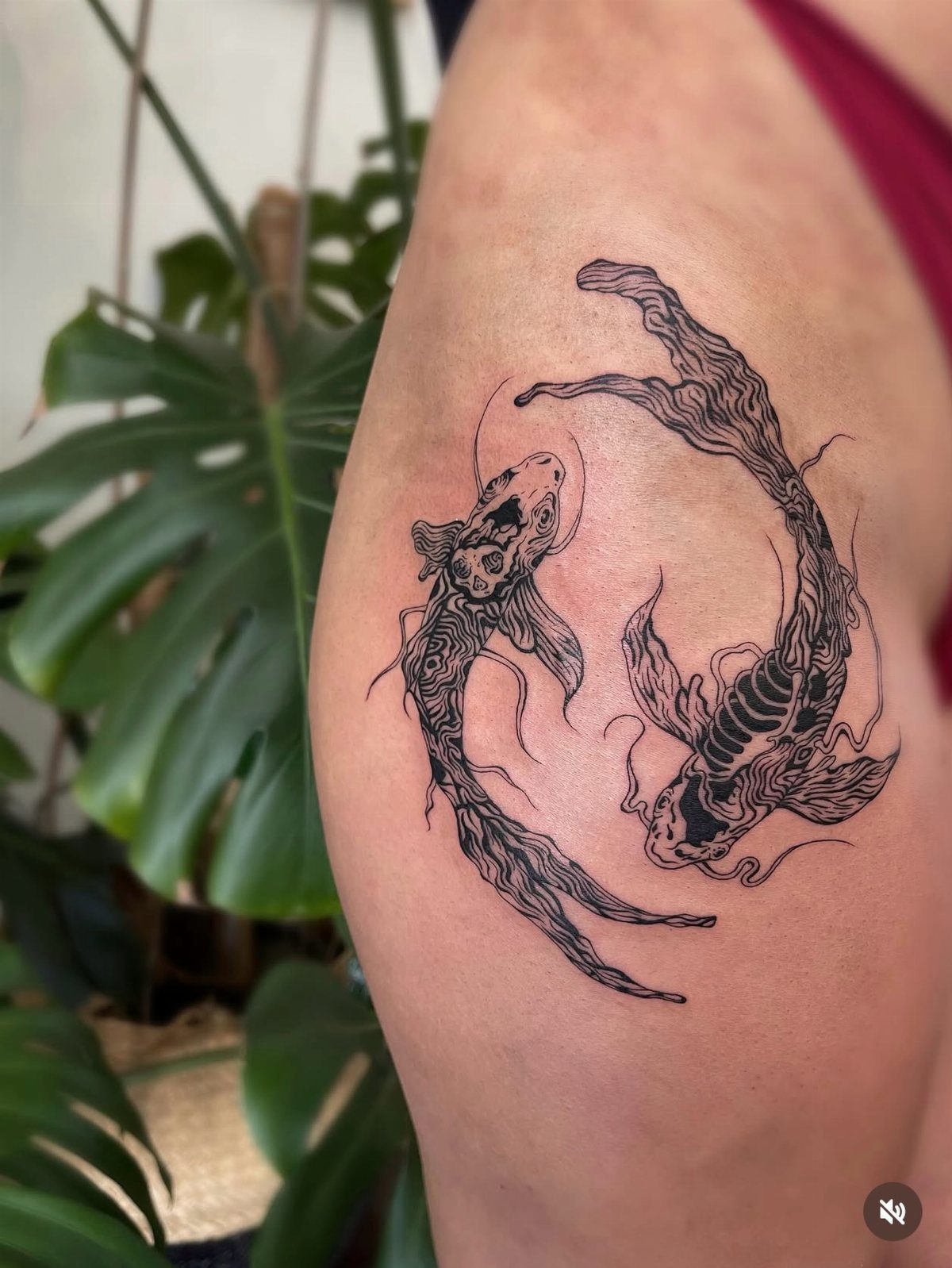 Koi fish skeleton tattoo on a thigh with two fish circling each other