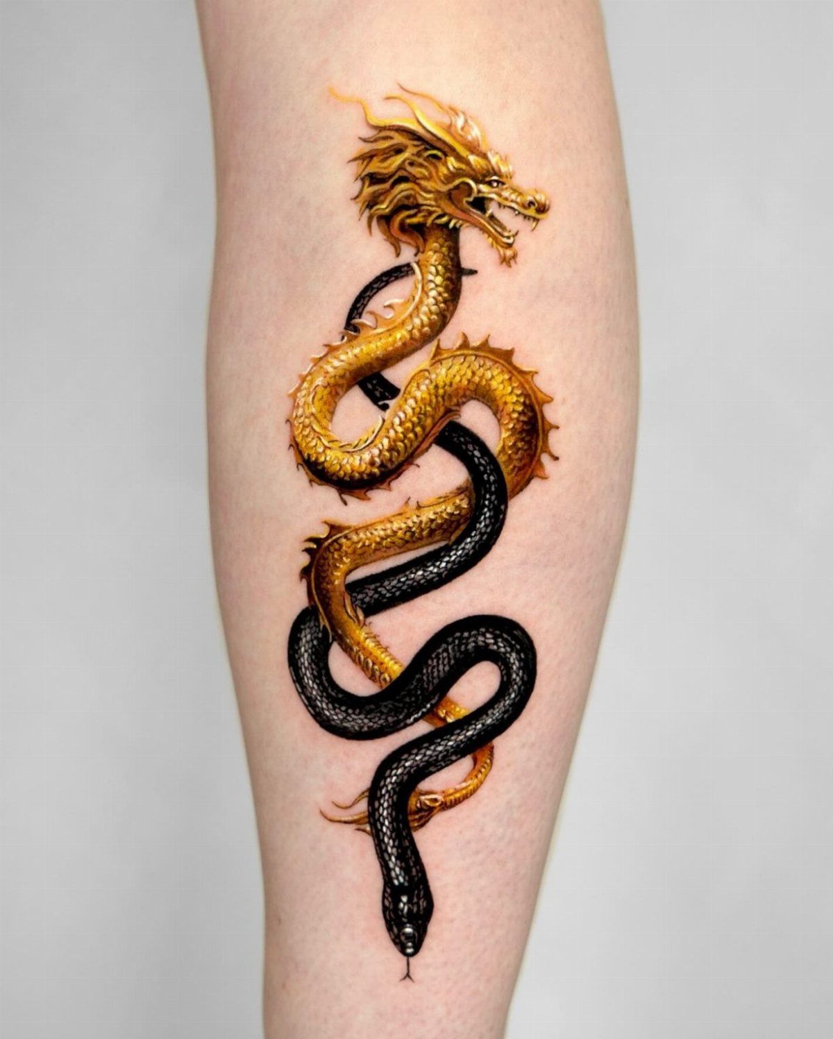 Golden dragon and black snake 3D tattoo on a person's forearm.