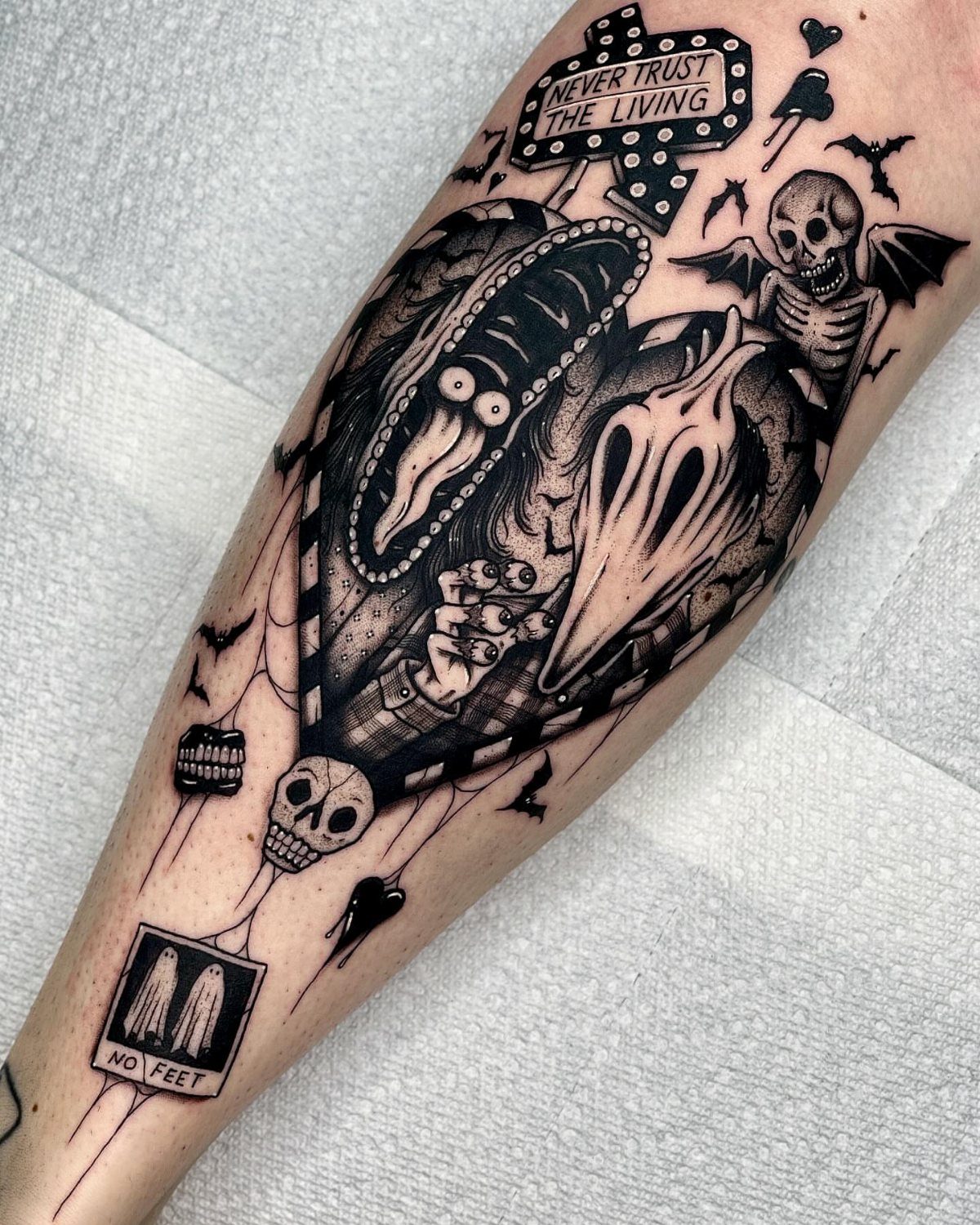 Beetlejuice tattoo on a leg featuring a monster, skeleton, and quote sign.