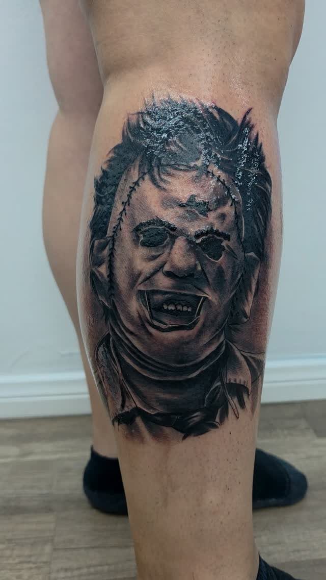 Frankenstein's monster portrait tattoo in black and grey ink on a person's calf