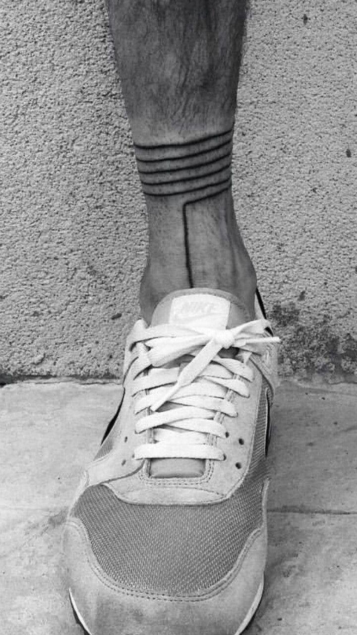 Lower leg tattoo with black bands wrapping around the ankle and a vertical line.