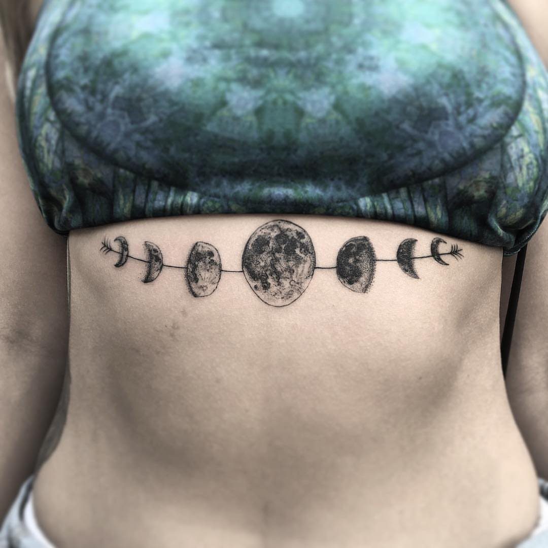 Moon phase tattoo on a person's stomach showing the lunar cycle in black ink.