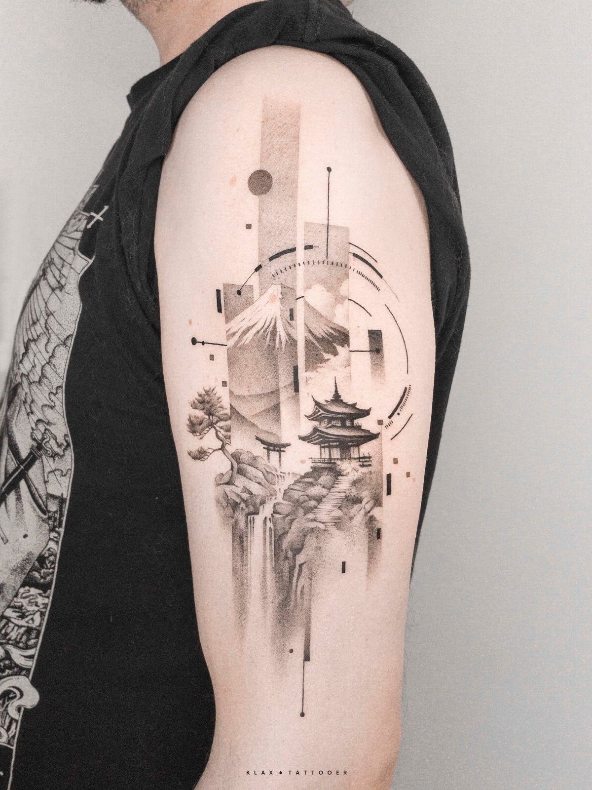 Japanese style mountain tattoo on upper arm featuring a pagoda and geometric shapes