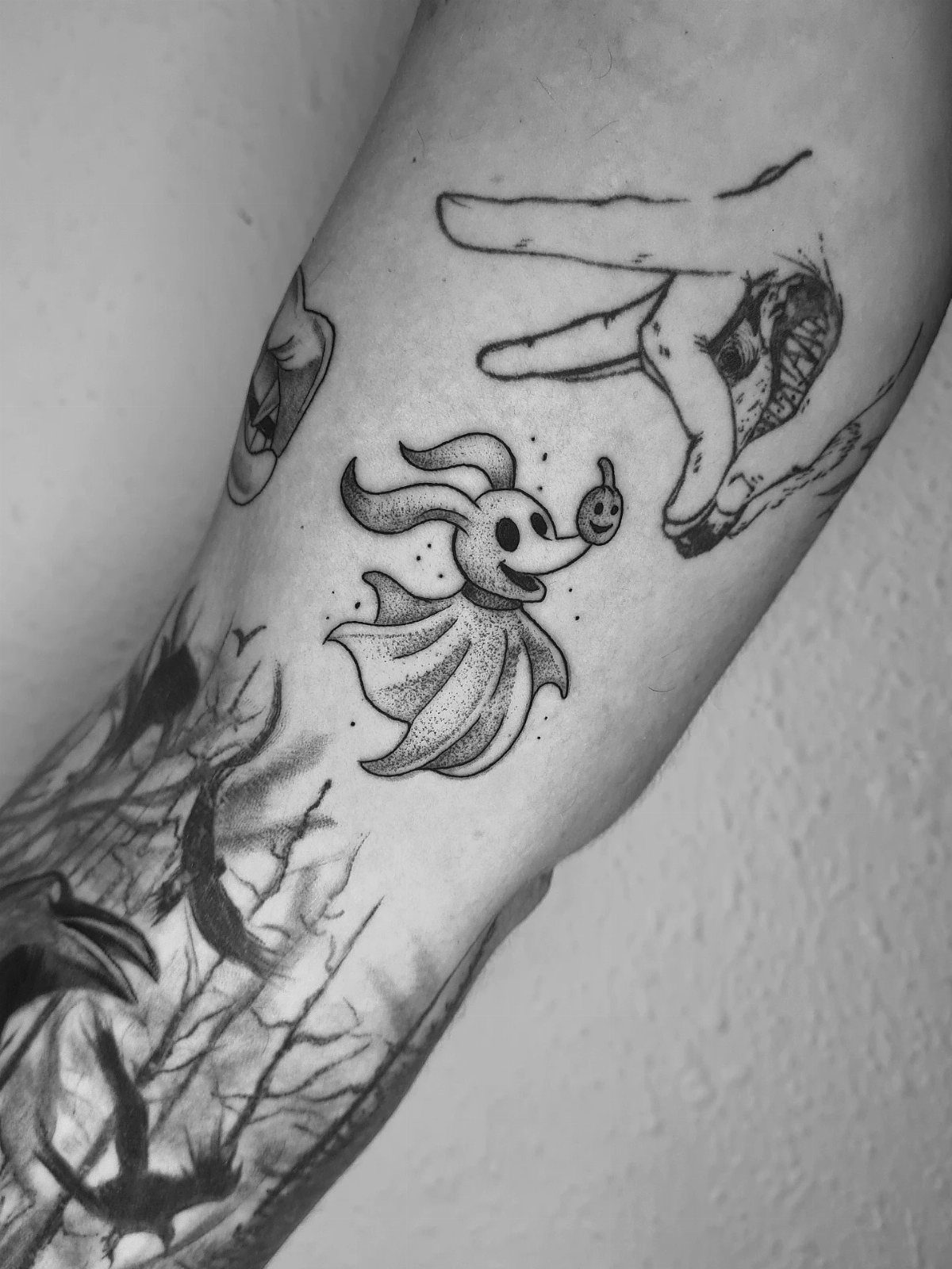 Zero the ghost dog tattoo on a person's arm with a skeletal hand.