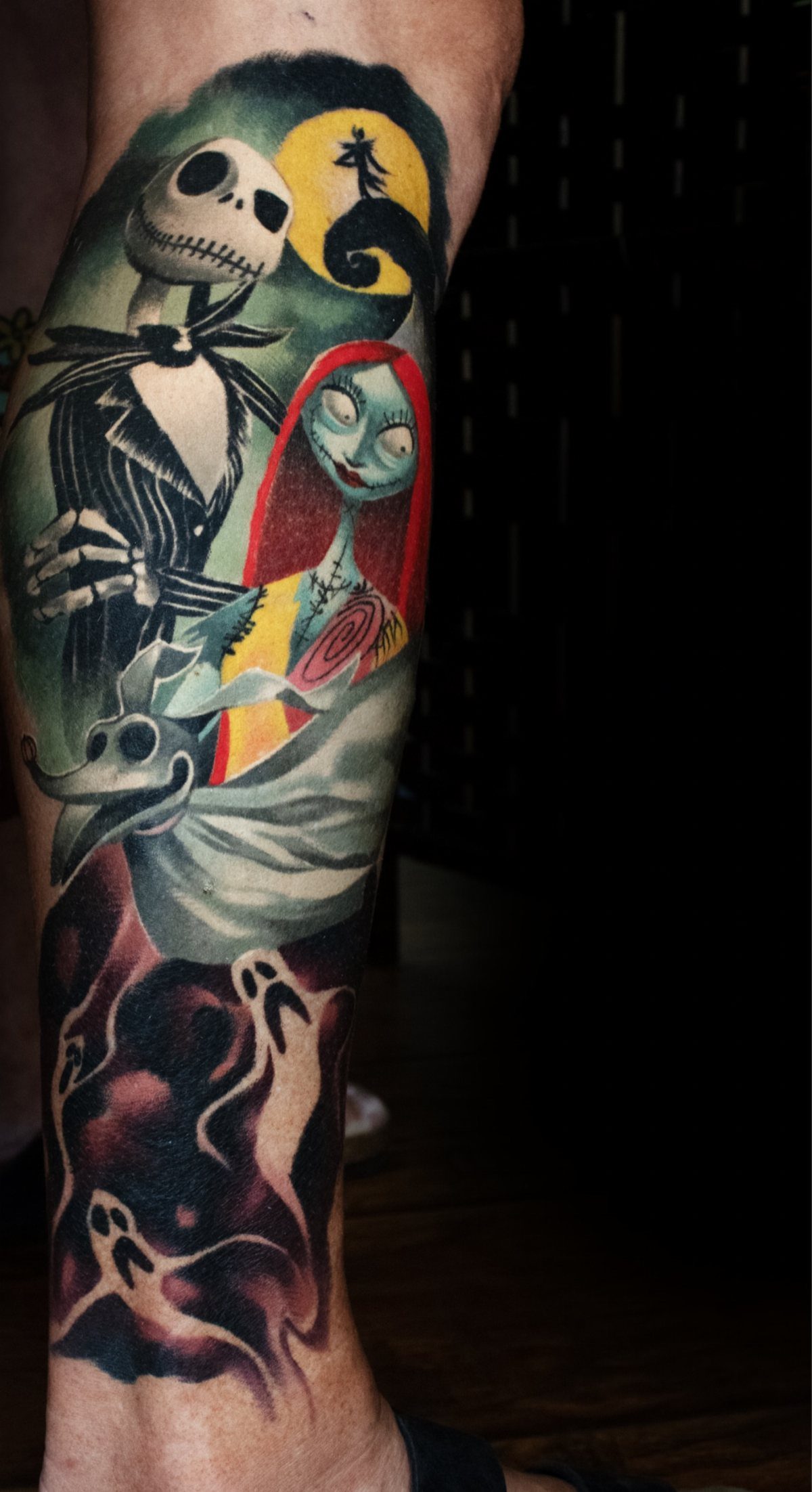 Colorful leg sleeve tattoo featuring Jack, Sally, and Zero from Nightmare Before Christmas.