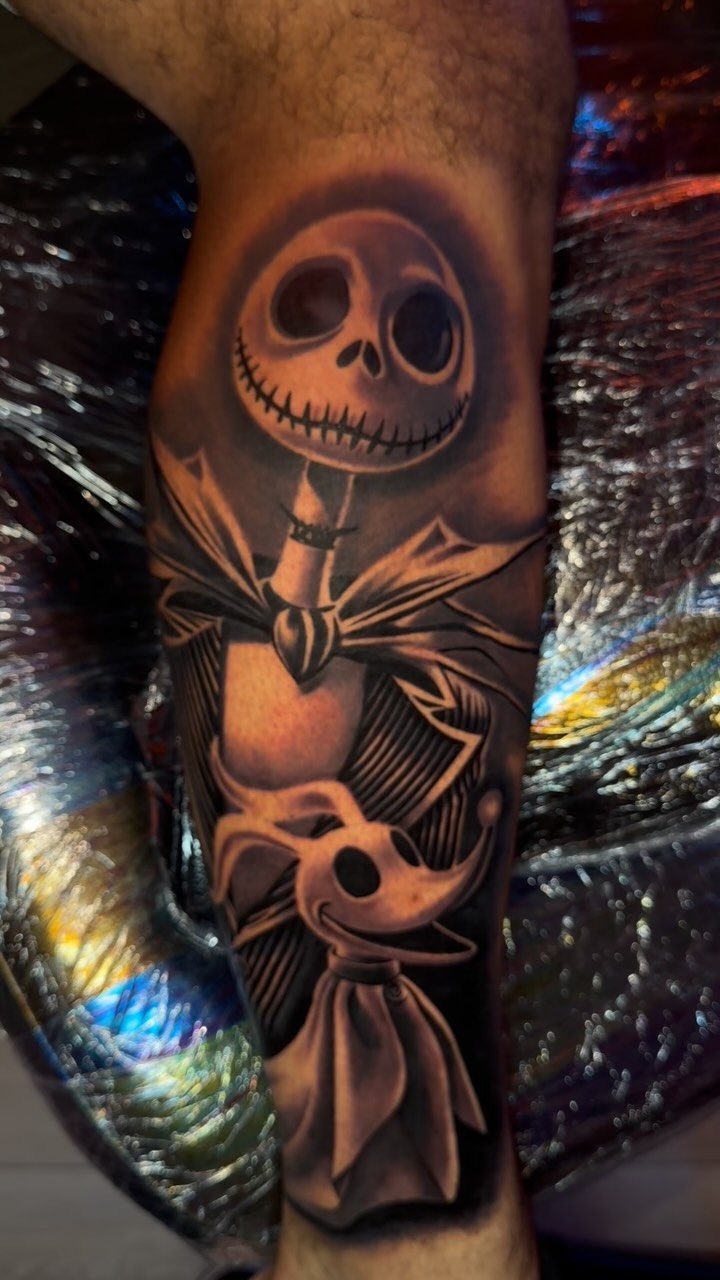 Jack Skellington and Zero tattoo in black and grey ink on a forearm.