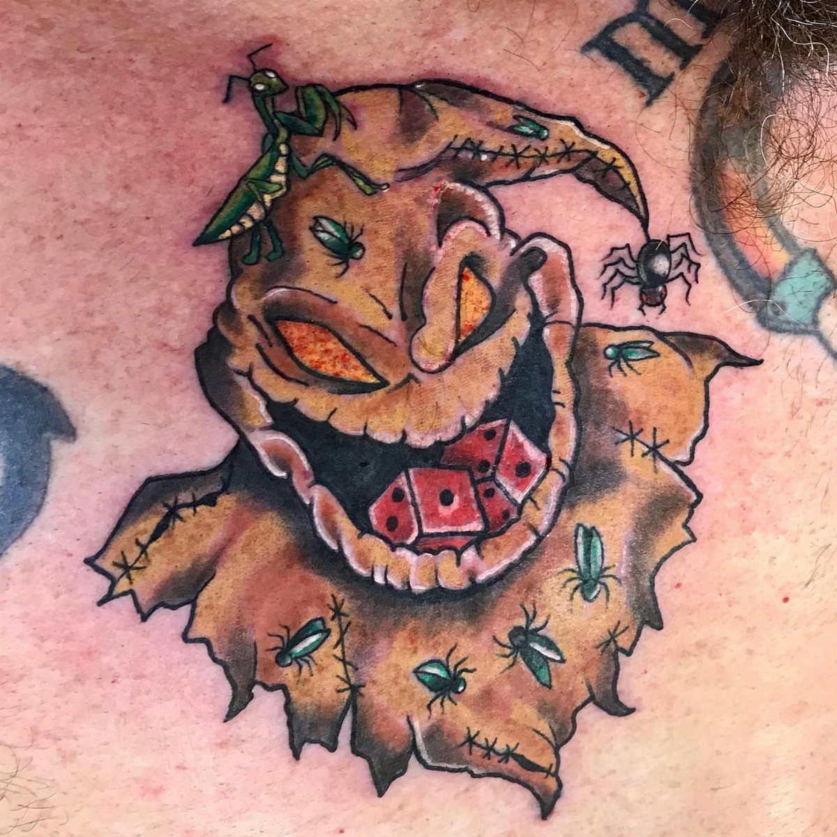 Oogie Boogie tattoo with glowing eyes, red dice, and insects on skin.