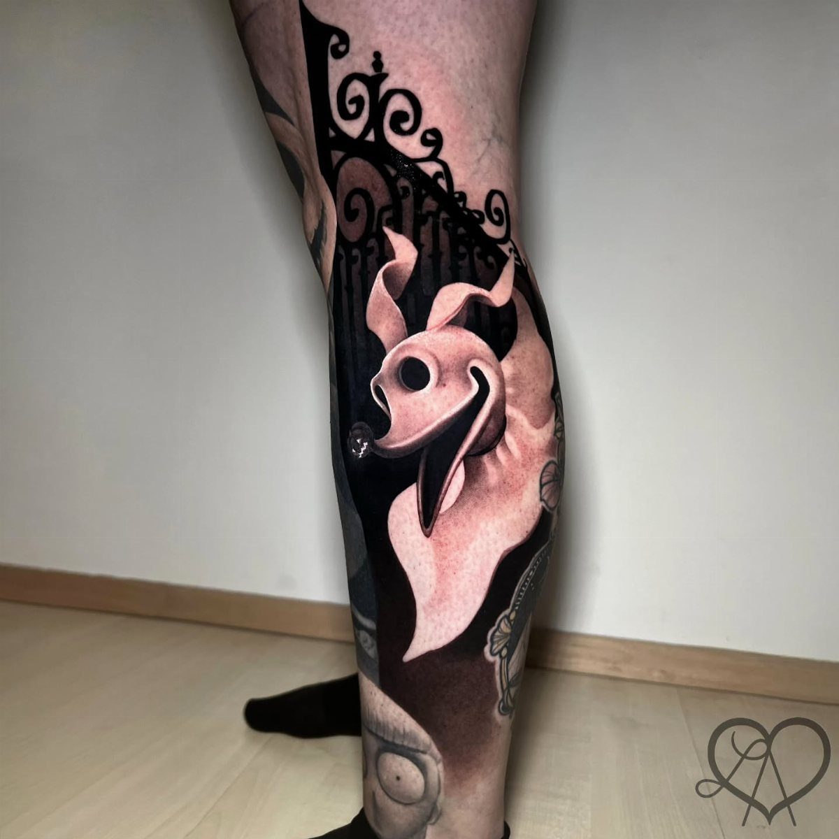 Zero the ghost dog tattoo on a calf with dark ornate background elements.