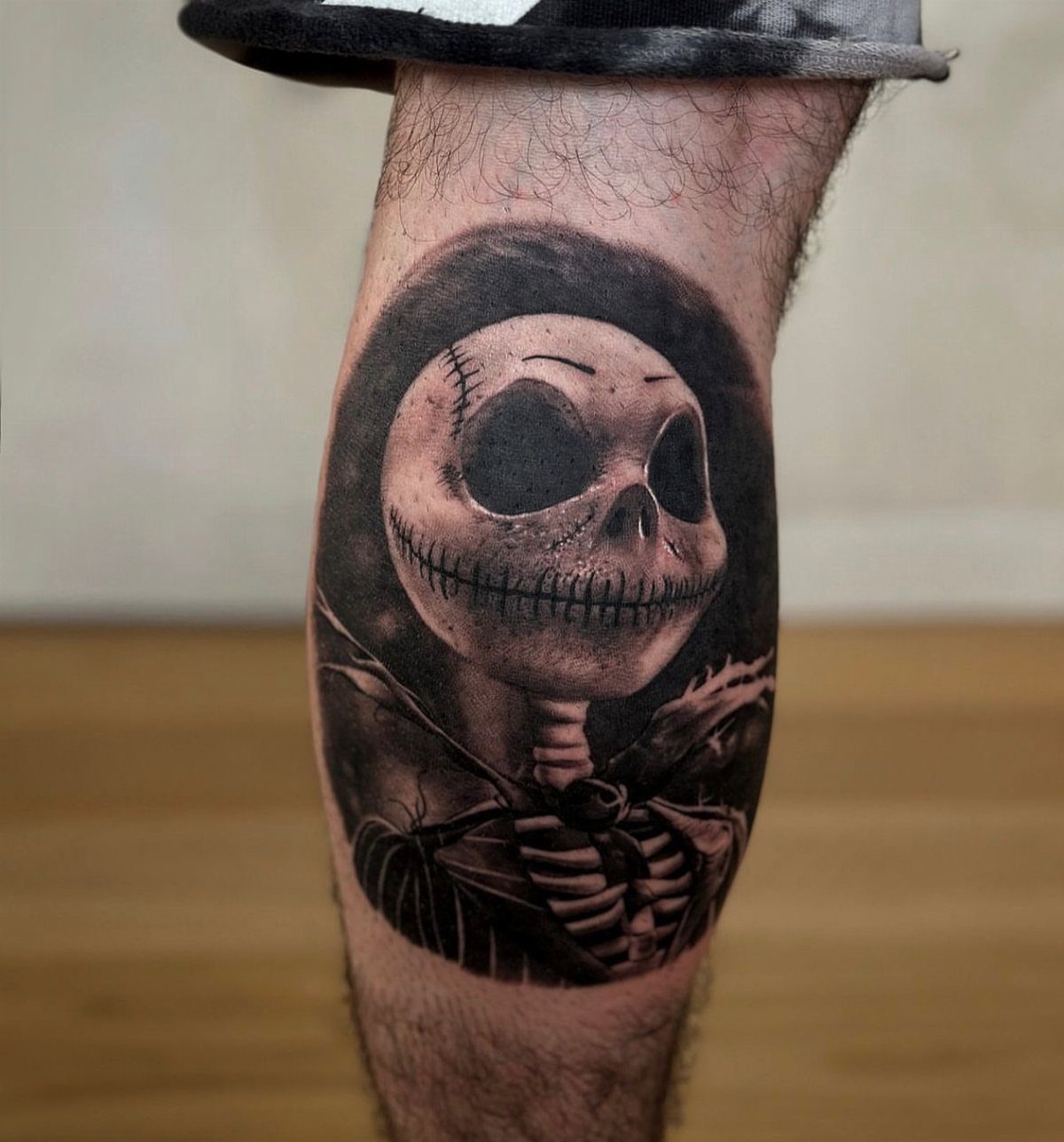 Jack Skellington tattoo on a calf with detailed black and grey shading.