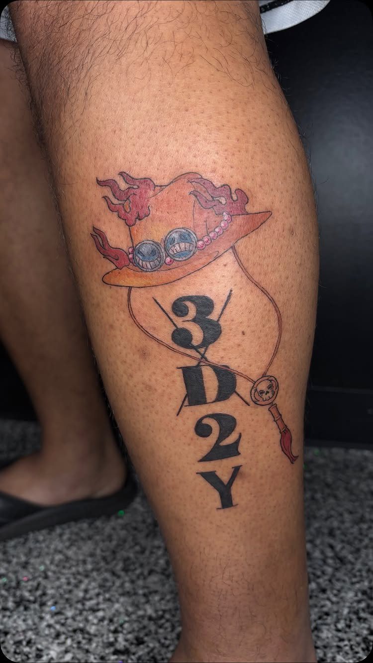 Tattoo on a leg showing a flaming straw hat and the text 3D2Y.