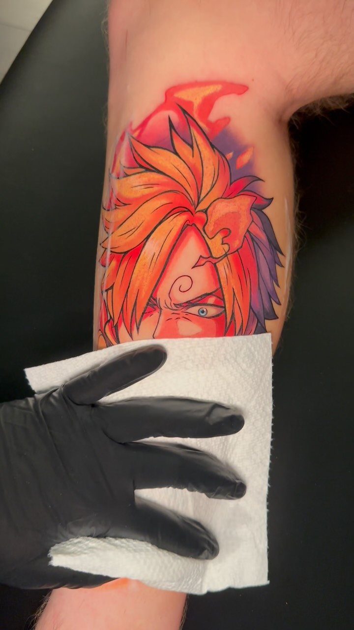 Sanji tattoo on an arm being wiped with a white paper towel
