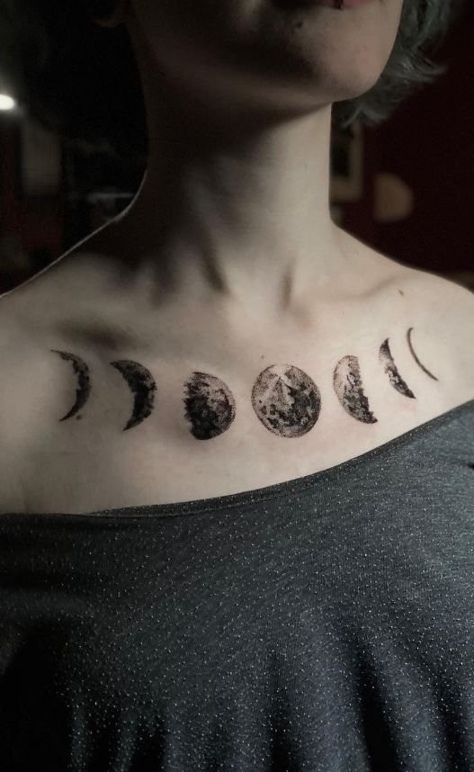 Moon phases tattoo arranged horizontally across the upper chest and collarbone area.