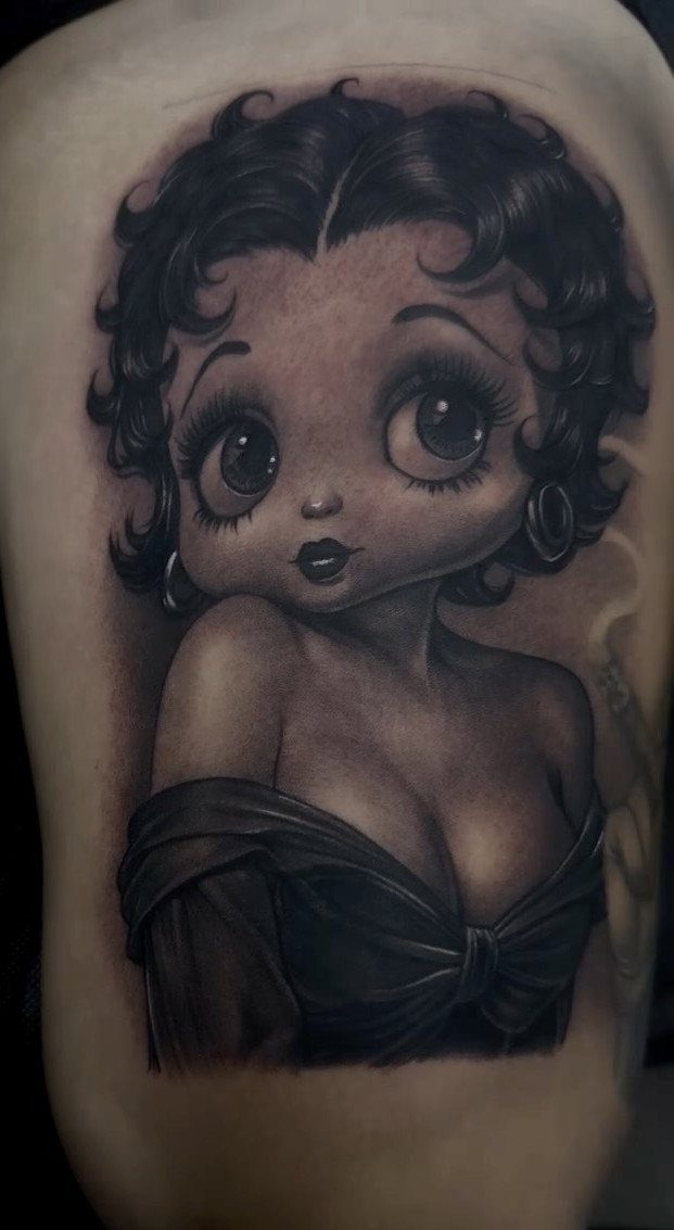 Betty Boop tattoo in black and grey ink on a person's skin