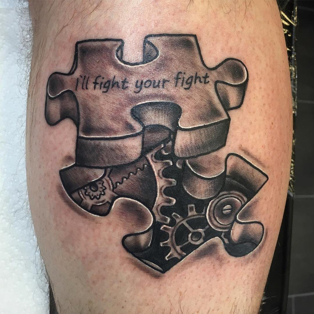 Puzzle piece tattoo on a leg with gears and the text I'll fight your fight