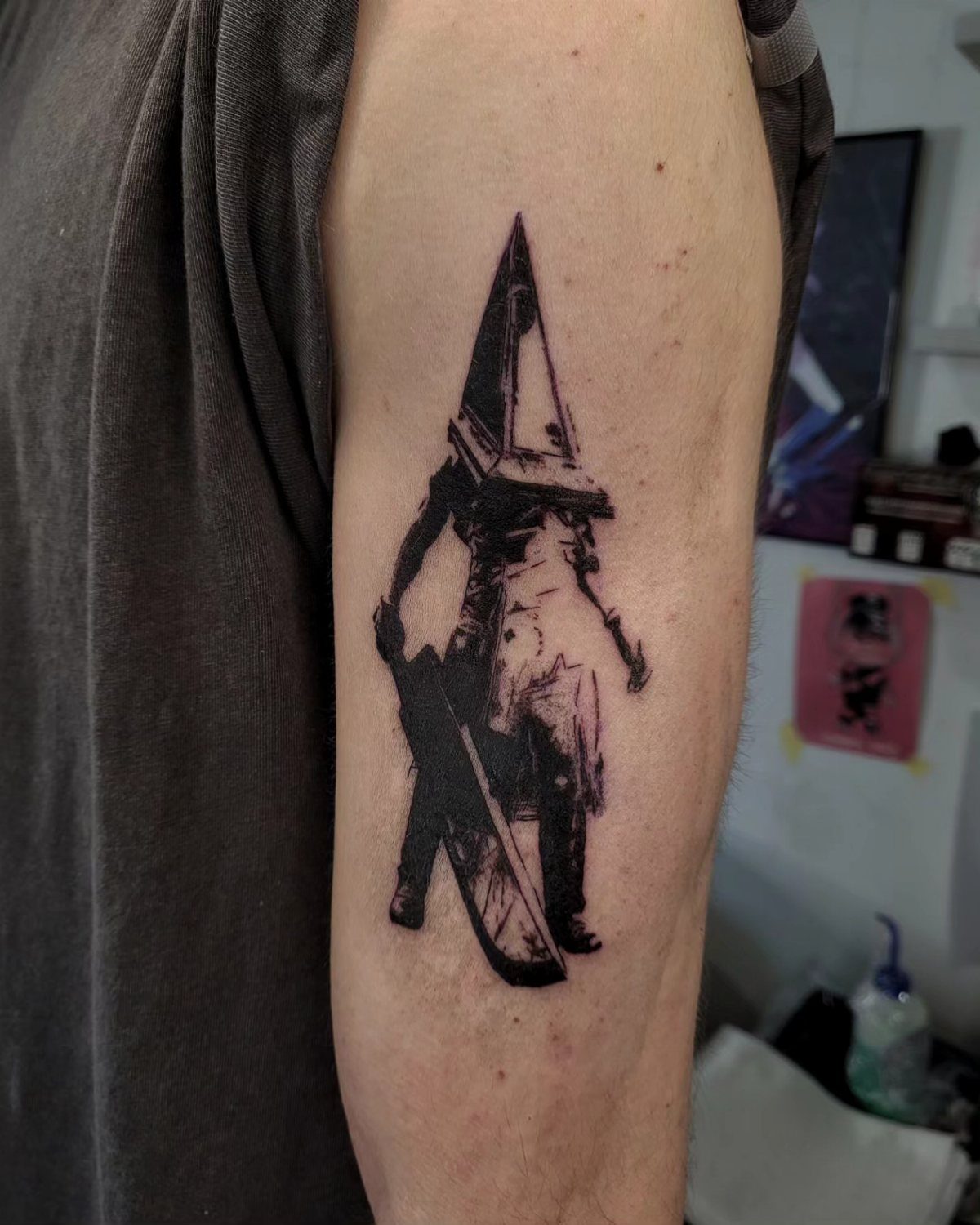 Pyramid Head tattoo on an arm featuring his helmet and great knife