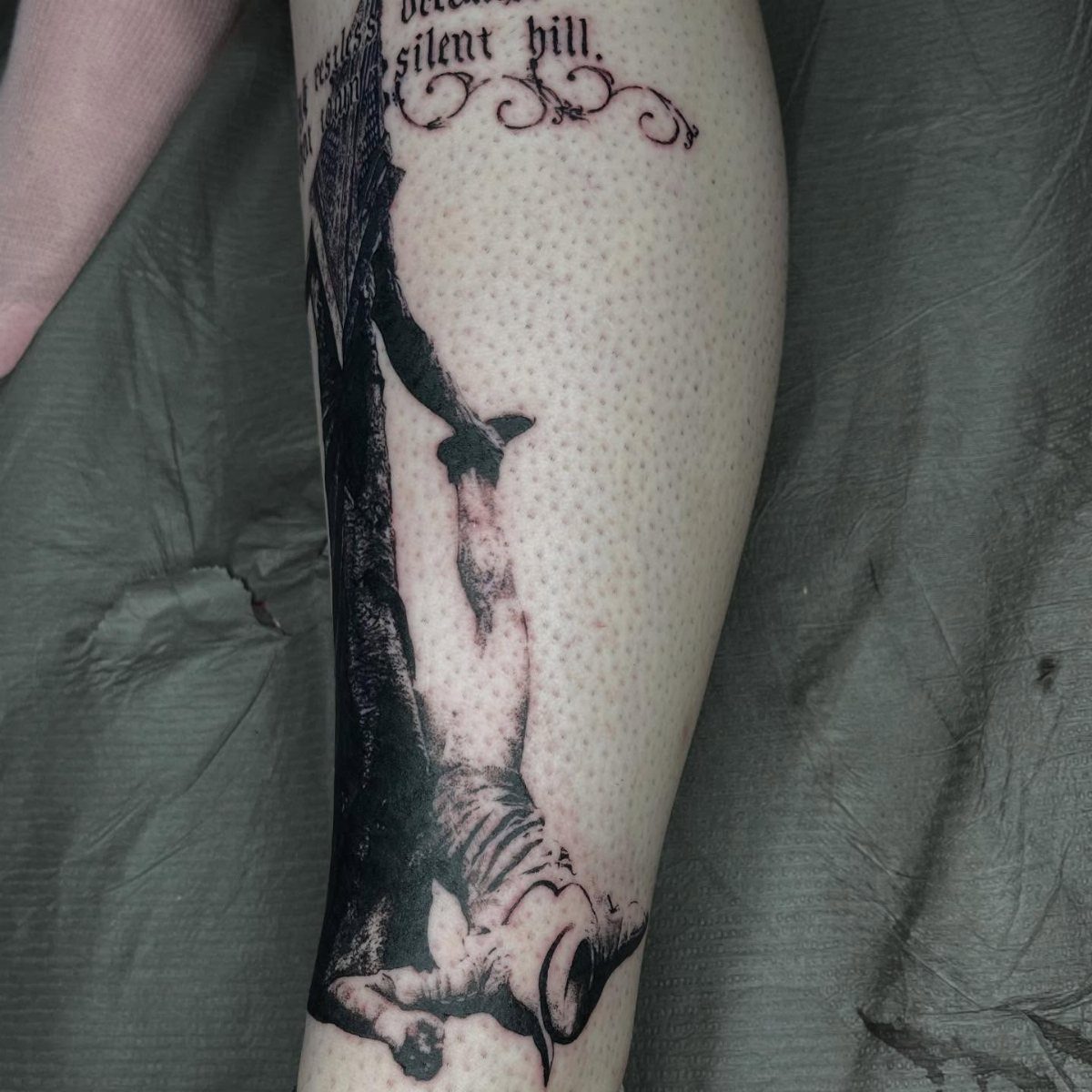 Pyramid Head tattoo on a leg with the words silent hill above it