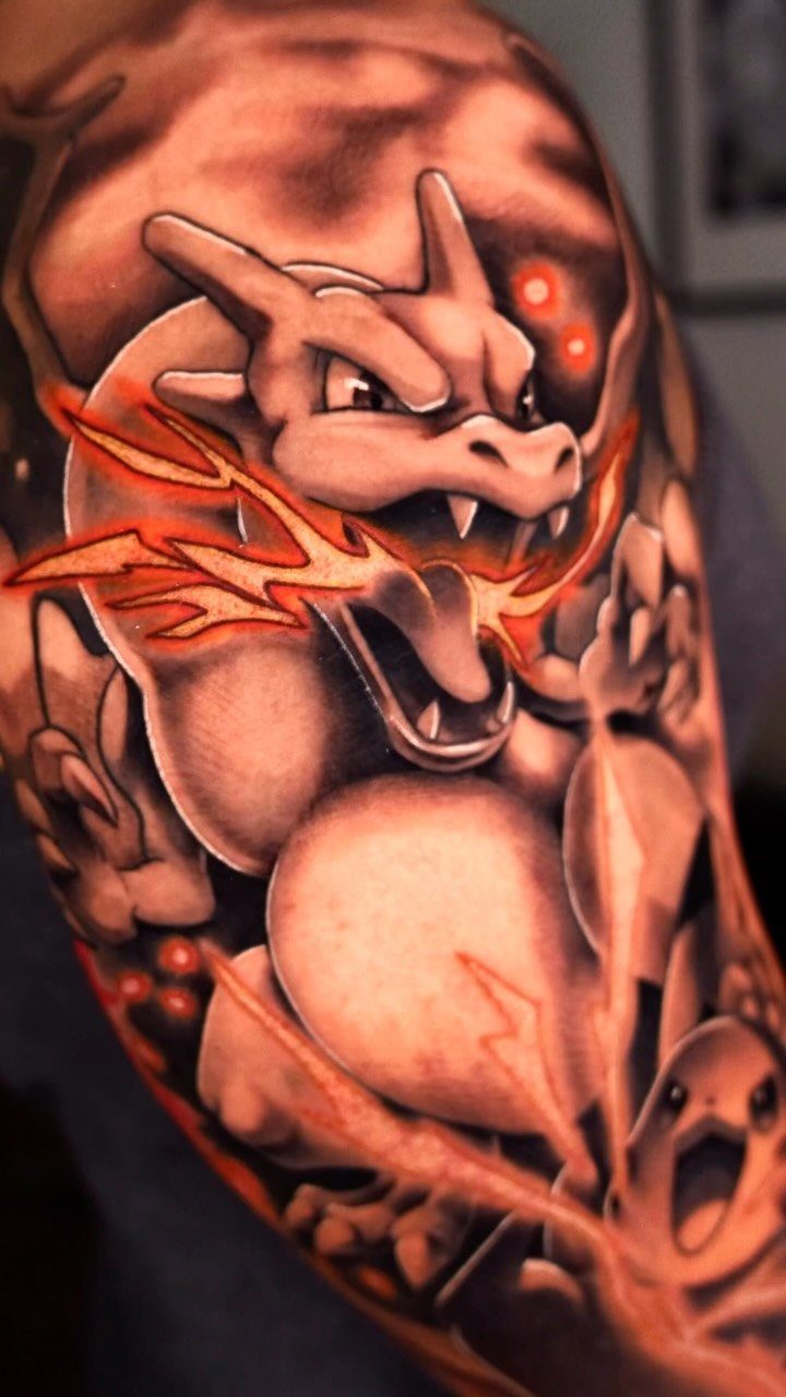Realistic Charizard tattoo on an arm breathing fire with a small Pikachu below.