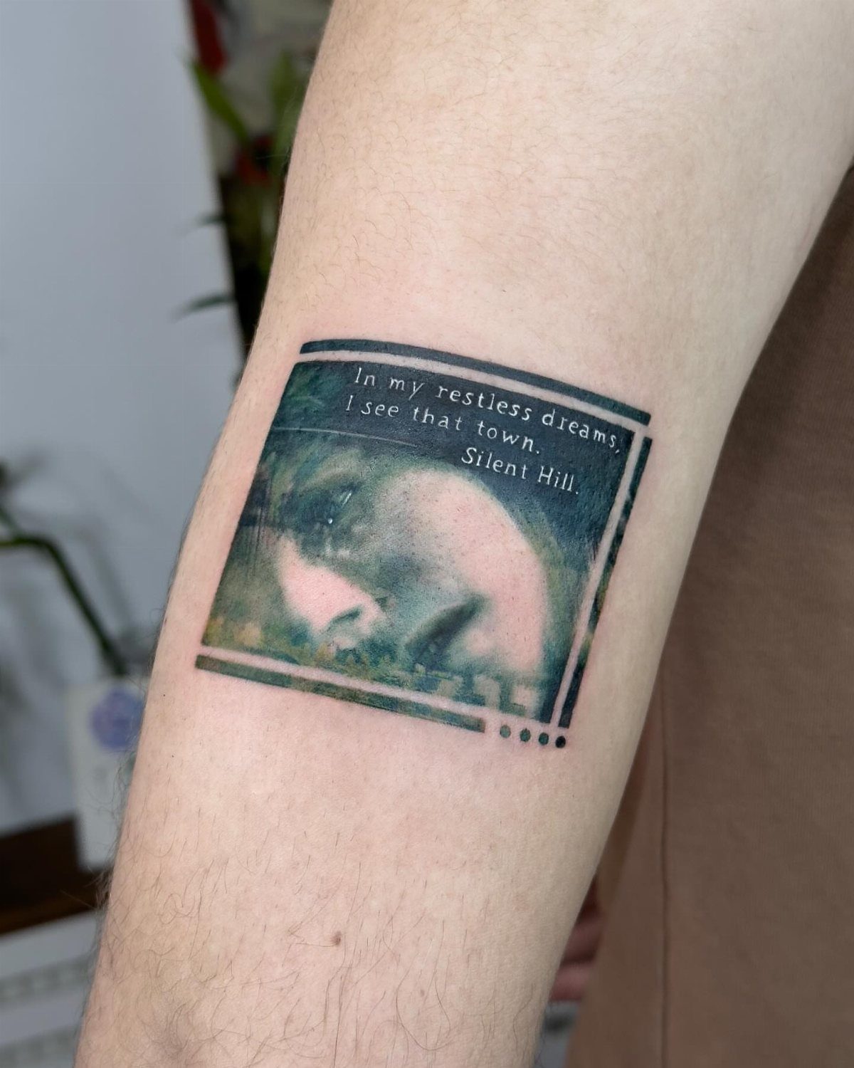 Tattoo on a forearm featuring a face and the text In my restless dreams.