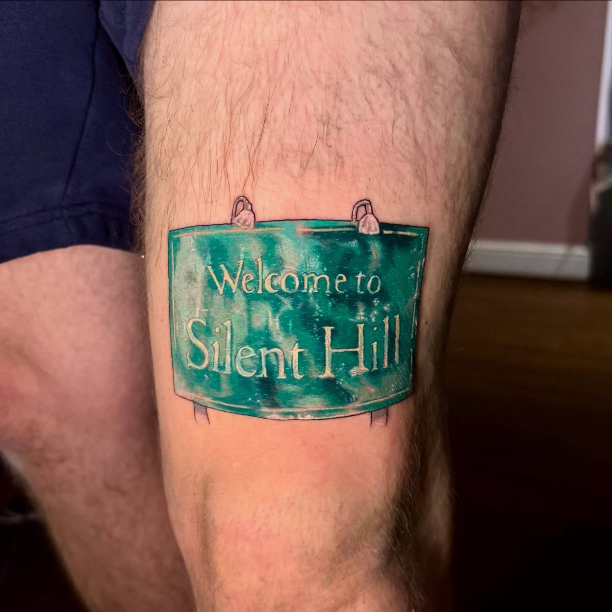 Welcome to Silent Hill sign tattoo on a person's hairy leg