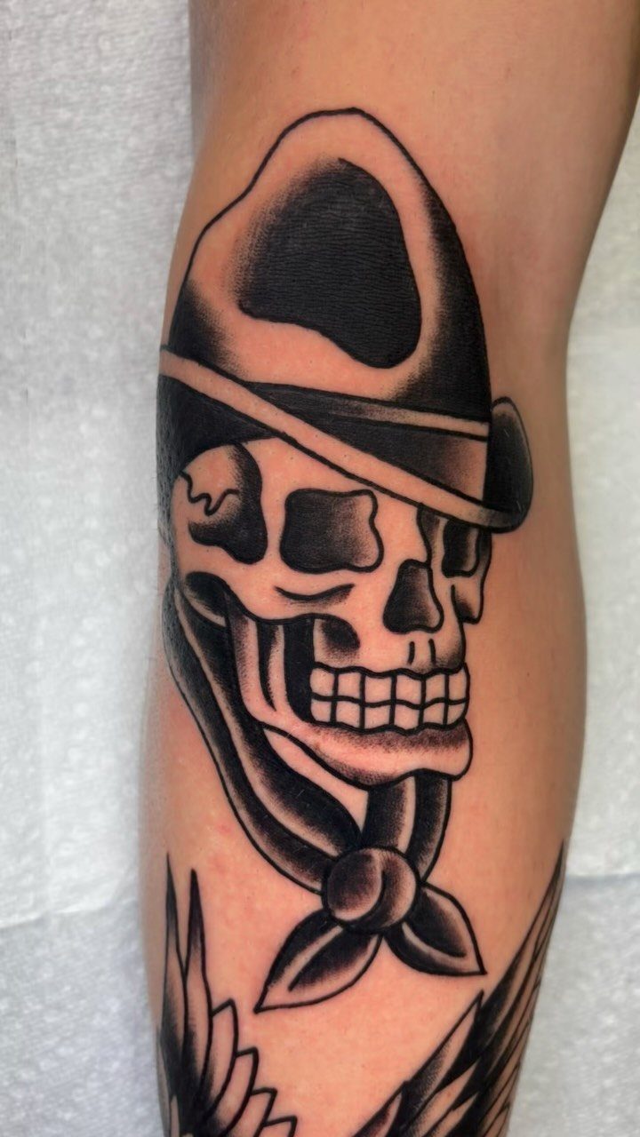 Skull tattoo wearing a bowler hat with bold black outlines on skin