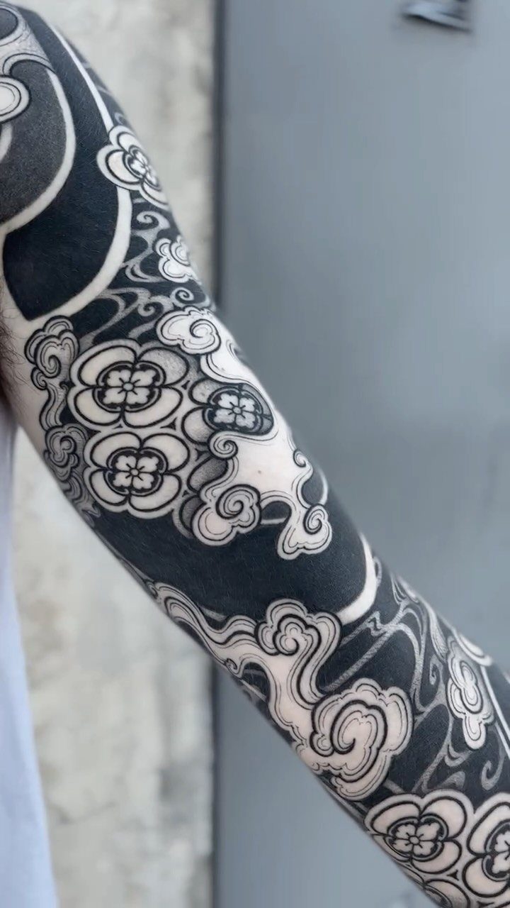 Japanese style storm cloud tattoo with swirling patterns on a person's arm.