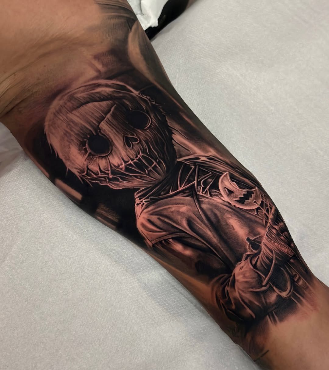 Jack Skellington tattoo in black and grey realism on a person's forearm