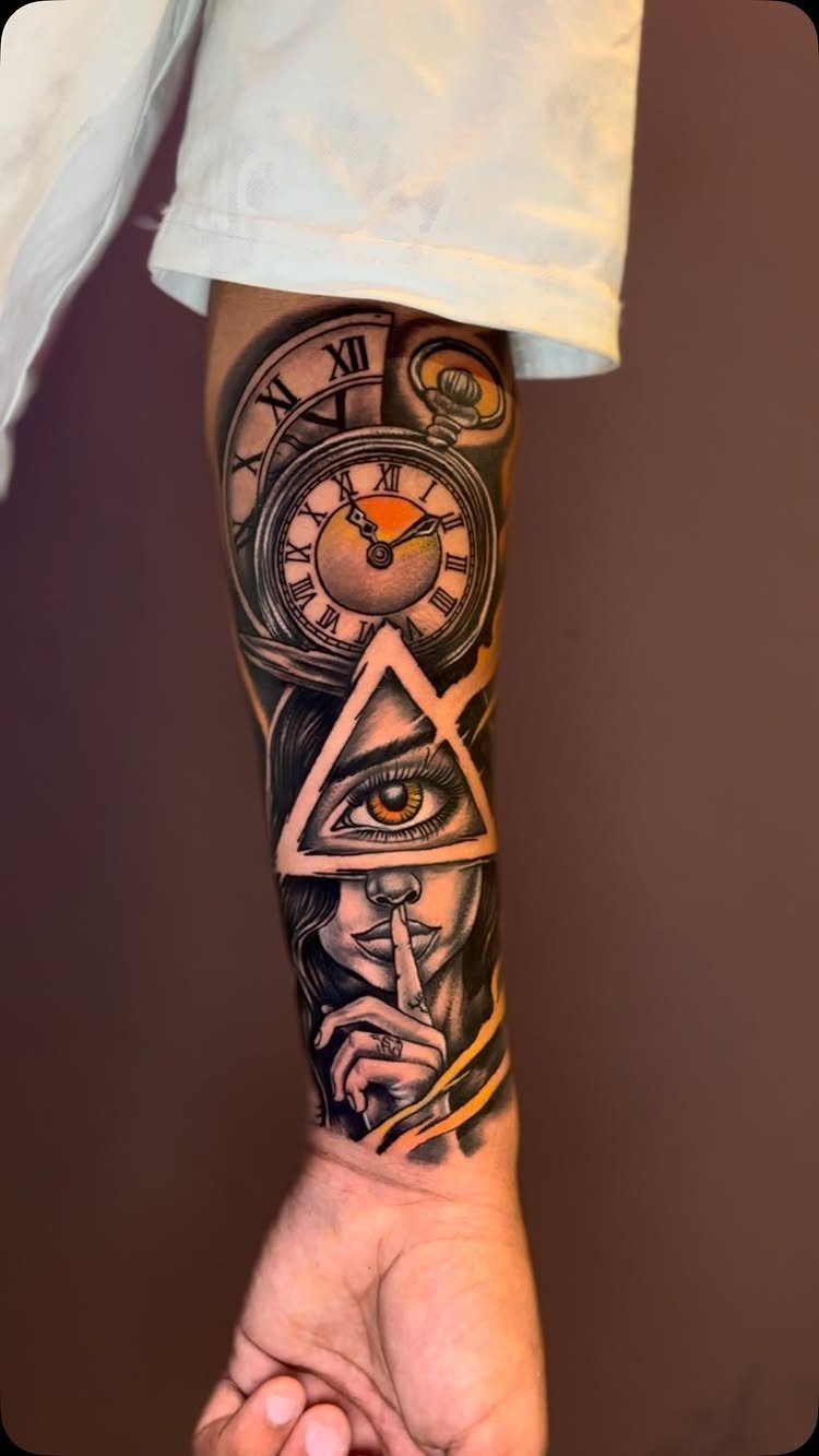 Forearm tattoo featuring a clock, an eye in a triangle, and a woman's face.