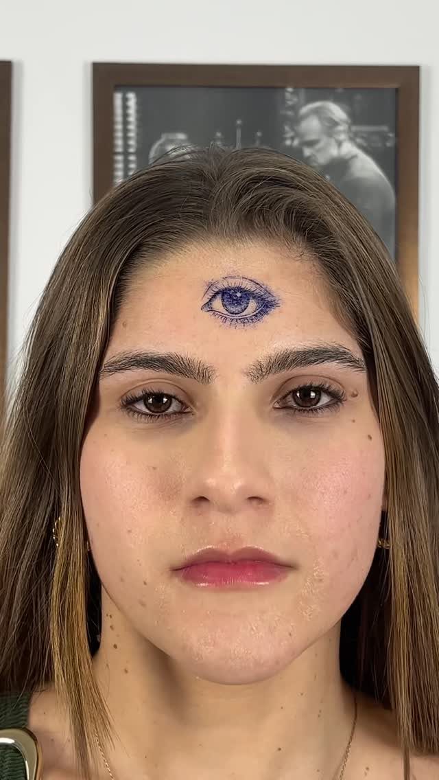 Woman with a blue third eye tattoo centered on her forehead.