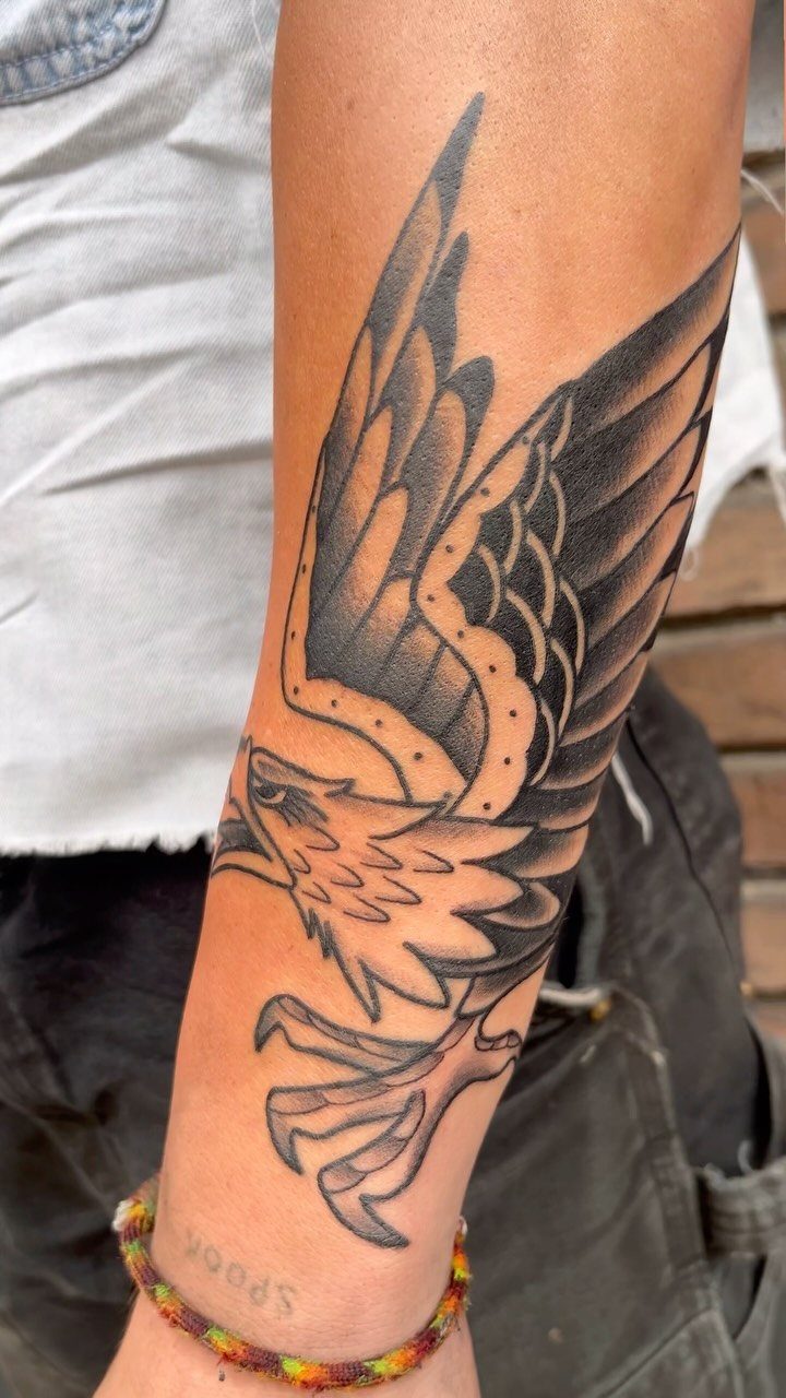 Traditional eagle tattoo with bold outlines on a person's forearm
