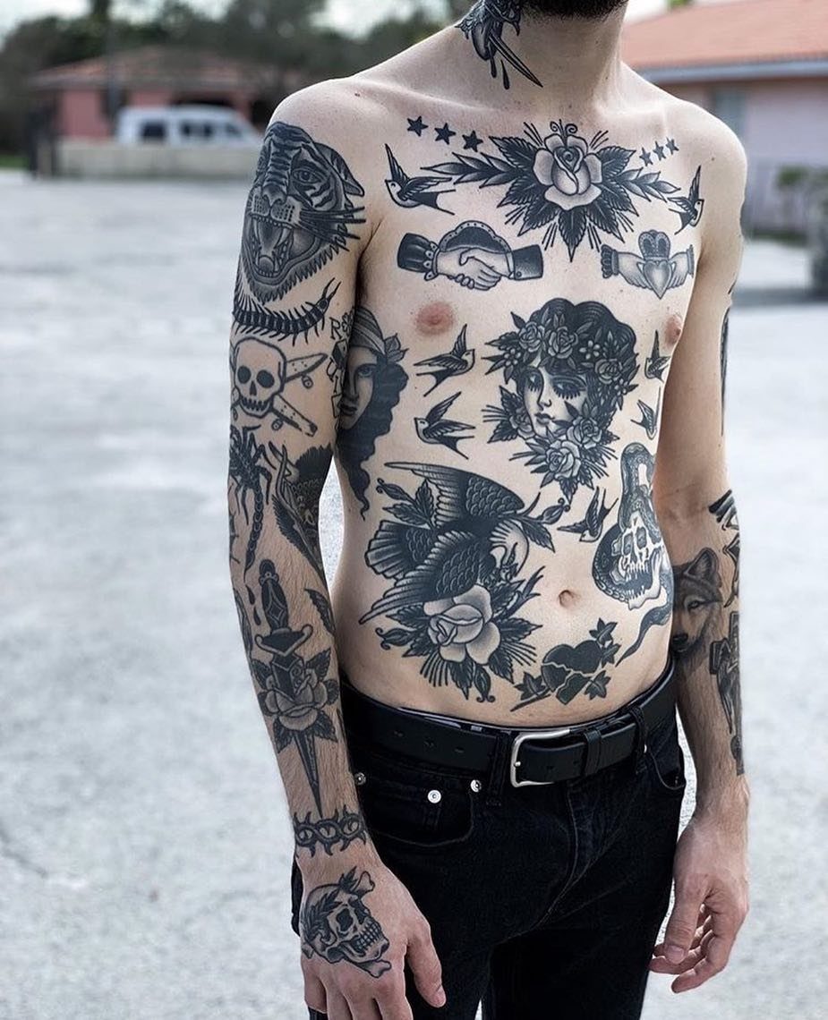 Man with traditional black and grey tattoos featuring bold outlines on his torso.